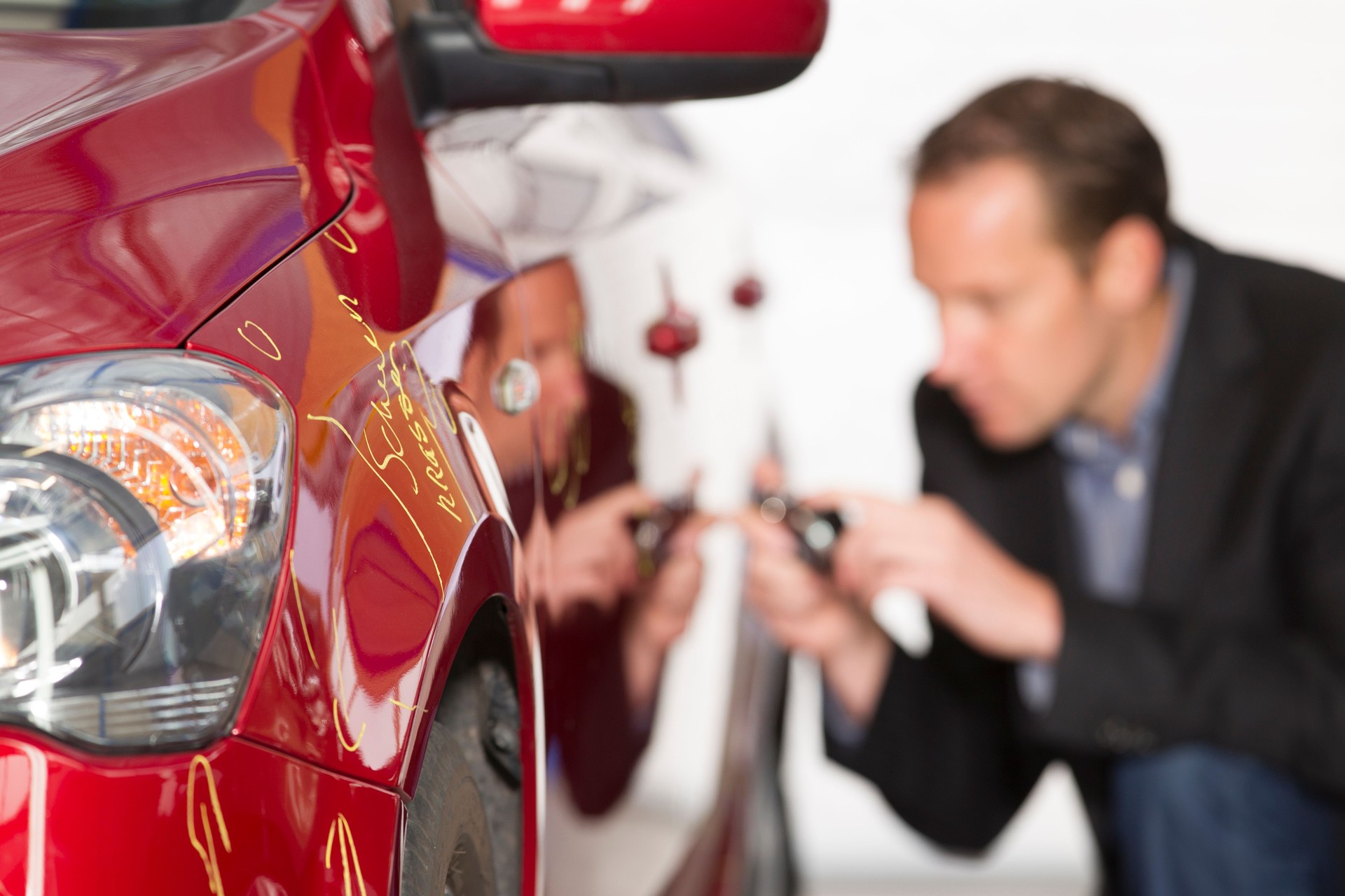 Adult appraiser looking at car, estimate for fix
